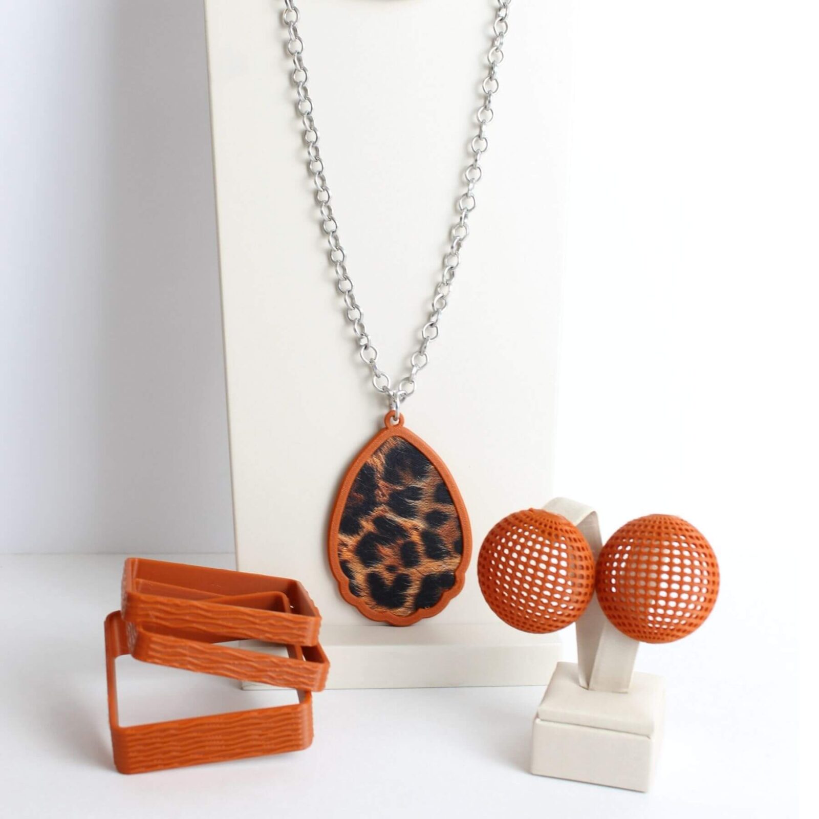 conjunto clau khawali com colar corrente de aluminio com pingente de onça, brinco marrom e pulseira tripla marrom