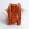 Pulseiras terracota empilhadas em PLA com textura ondulada, exibidas em almofada de apoio