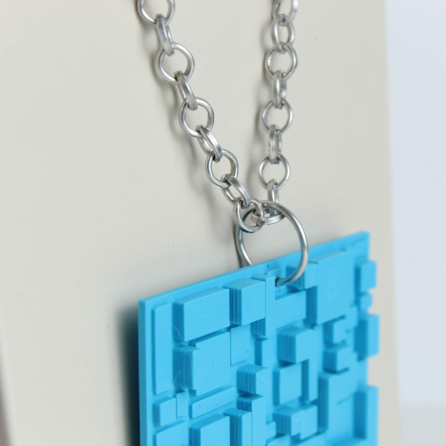 Corrente metálica de alumínio com anel de ajuste ligada ao pingente azul geométrico