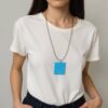 Mulher vestindo camiseta branca usando colar longo com pingente geométrico azul em PLA