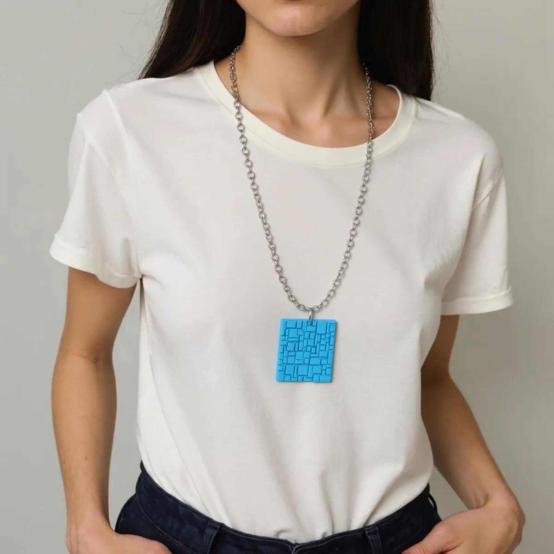 Mulher vestindo camiseta branca usando colar longo com pingente geométrico azul em PLA
