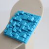 Close no relevo tridimensional do brinco azul em PLA com acabamento fosco