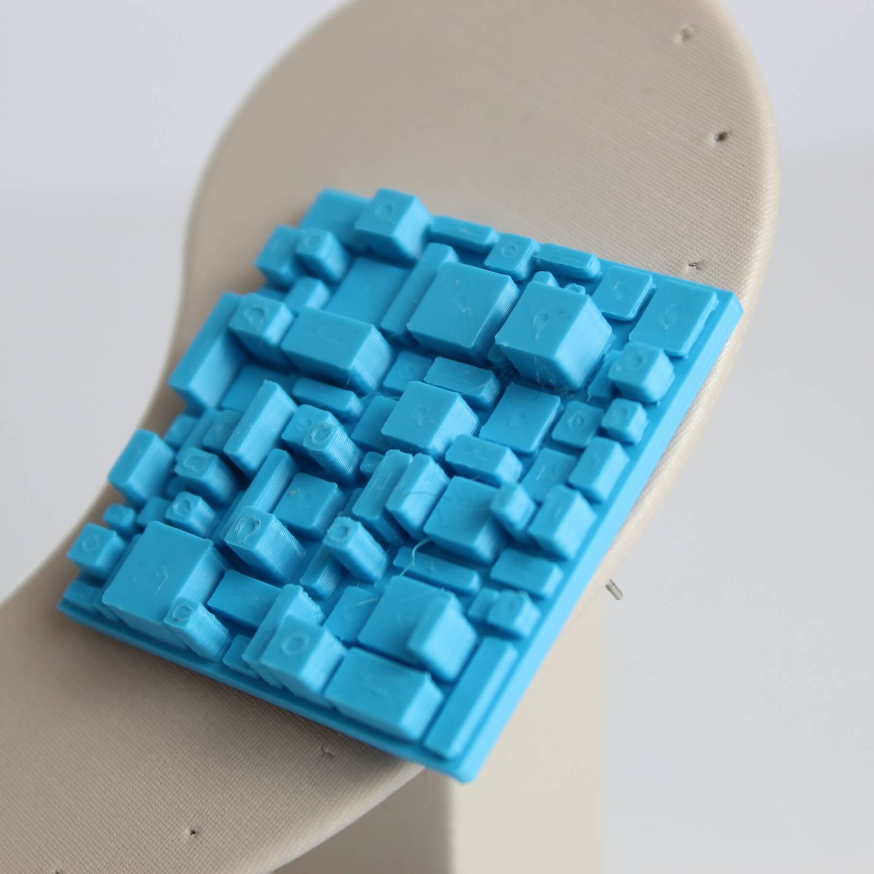 Close no relevo tridimensional do brinco azul em PLA com acabamento fosco