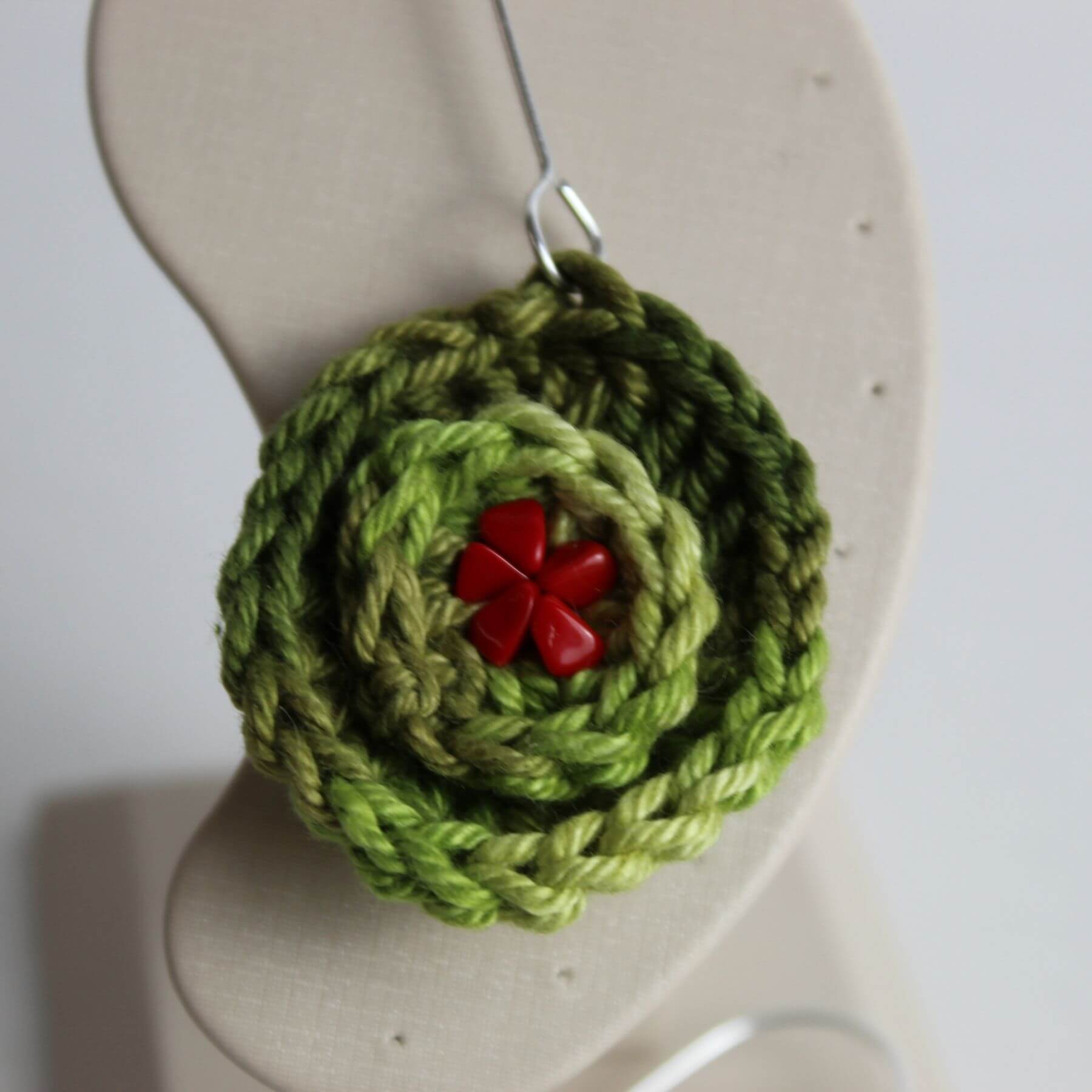 Detalhe da flor em crochê verde com miolo vermelho do brinco