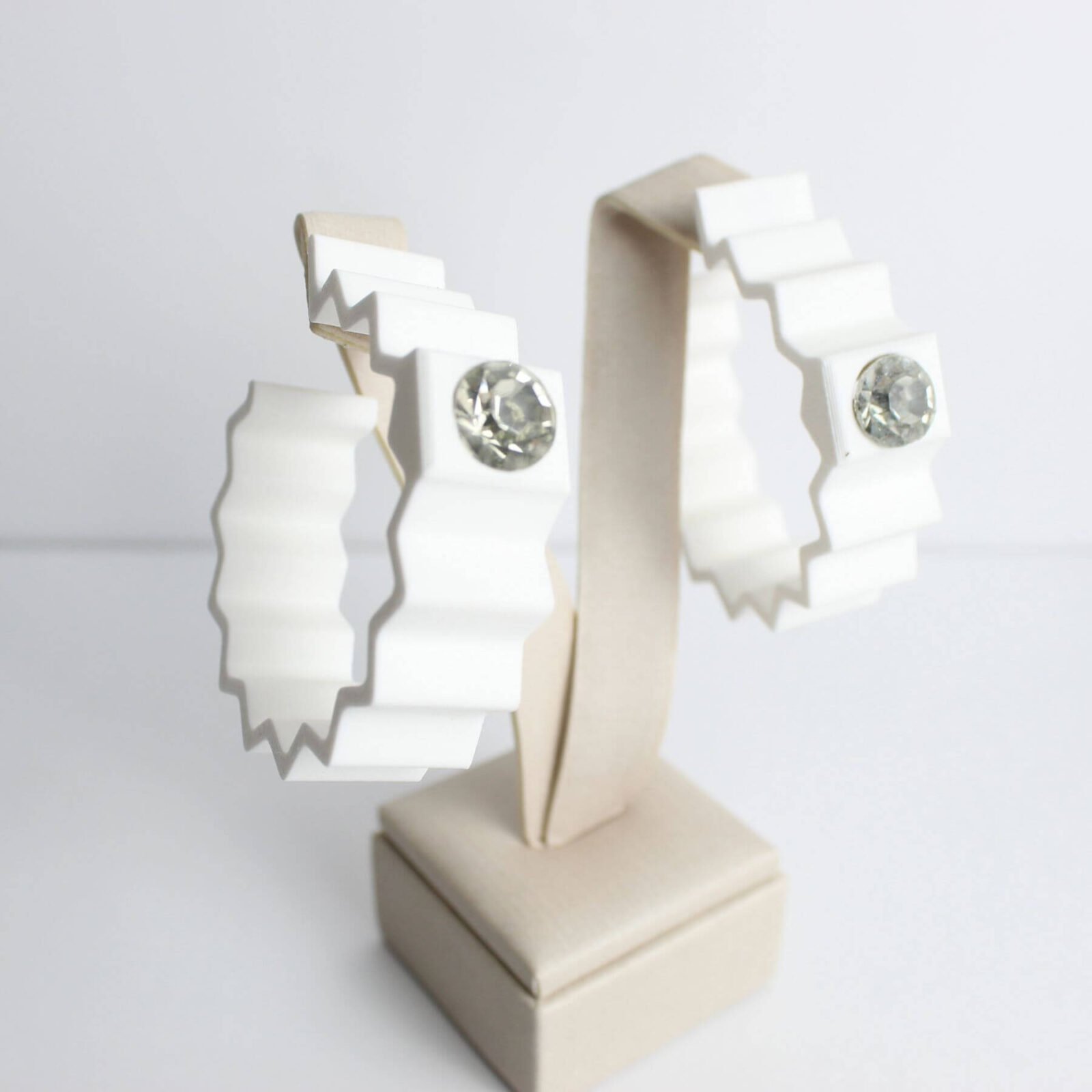 Brinco Branco com Strass – Design Ondulado Moderno