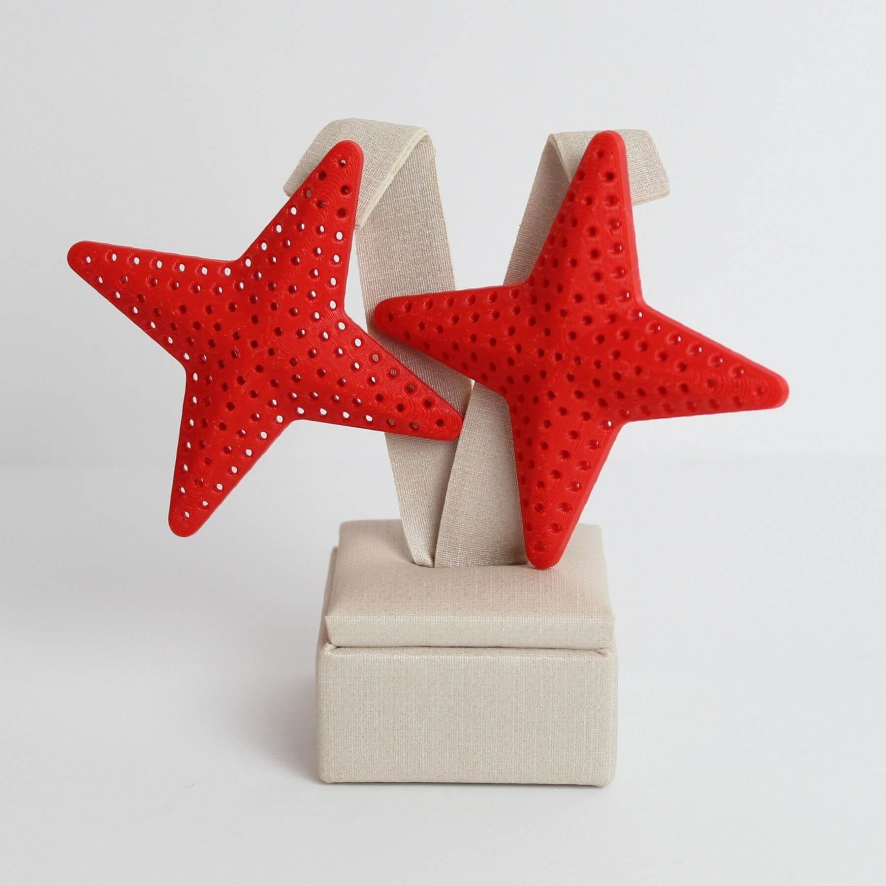 Brinco estrela vazada vermelho